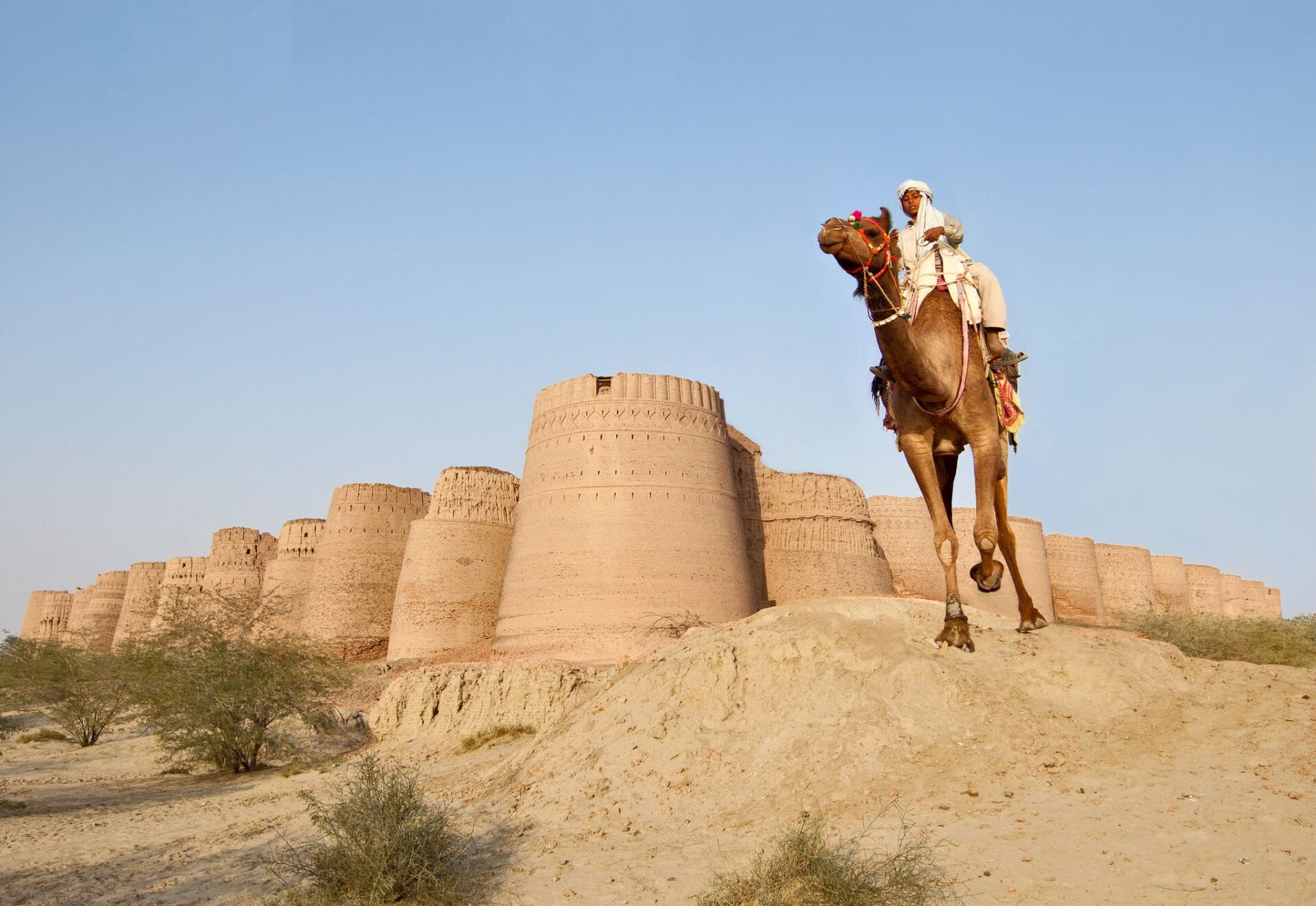 Historic Derawar Fort rising above the golden sand dunes of Cholistan Desert in Punjab, Pakistan.